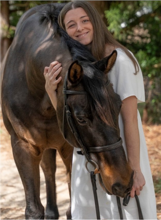 Sage standing with her horse